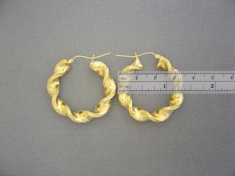 Close-up of hinged snap latch closure on 10K yellow gold 8mm twisted hoop earring