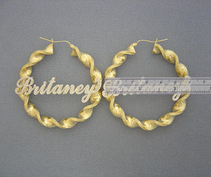 Close-up of personalized iced out nameplate on 10K gold 2.3 inch twisted hoop