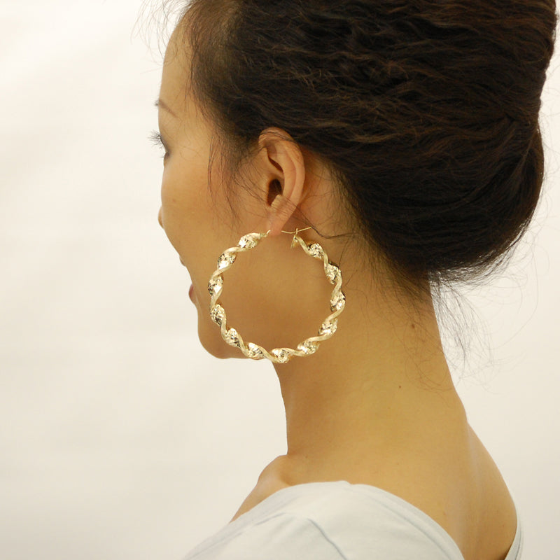 Model wearing 2.75 inch large 10K yellow gold thick twisted hoop earrings