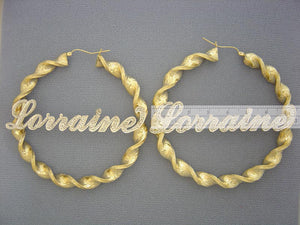 Close-up detail of two-tone iced out custom name on 10k gold hoop earring