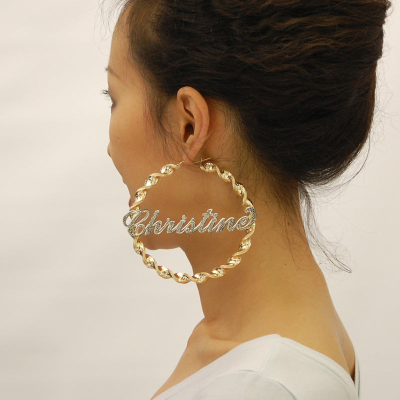 Detail view of 10K two tone gold iced out lettering on 8mm twisted hoop earring