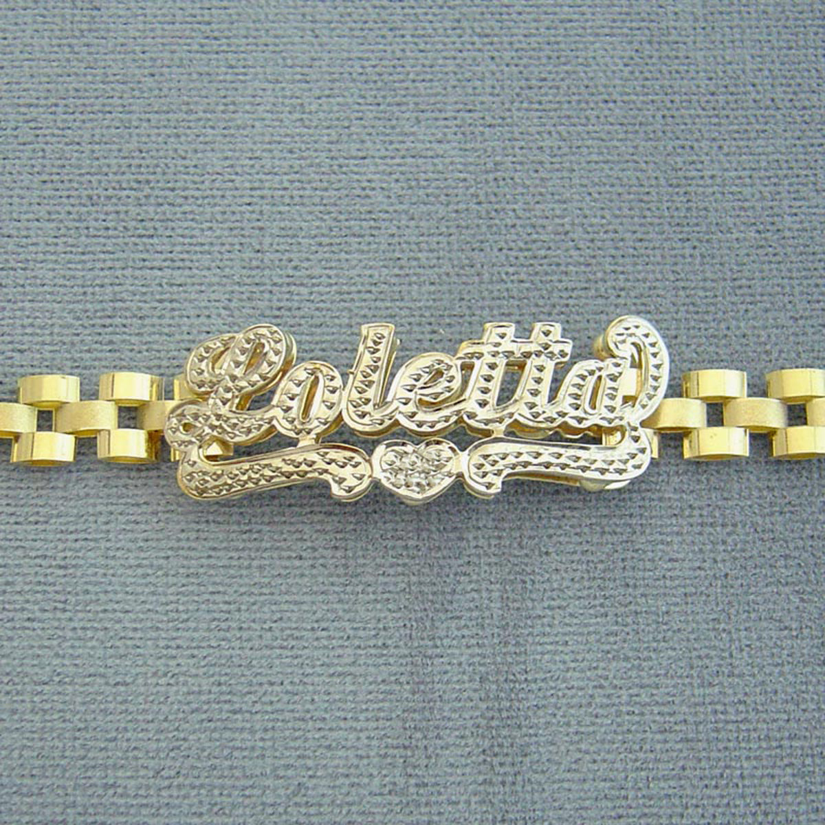 Detail of hand-engraved 3D iced out nameplate on 10K gold presidential link band