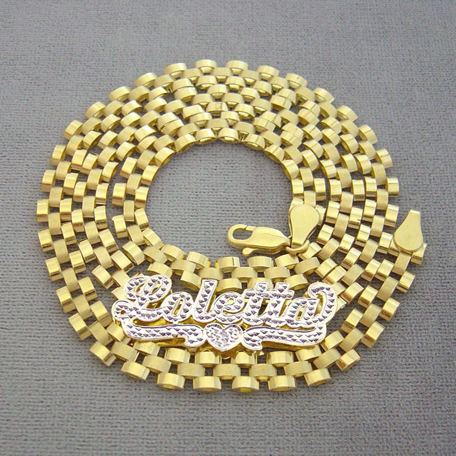 Close-up of hand-engraved 3D iced out nameplate with 10K gold watch-band link chain