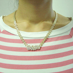 Model wearing custom 10K gold iced out nameplate necklace on striped shirt