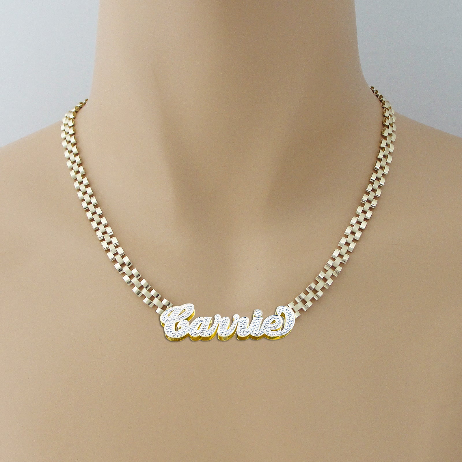 Model wearing personalized 10K gold iced-out nameplate necklace on 6mm watch band chain