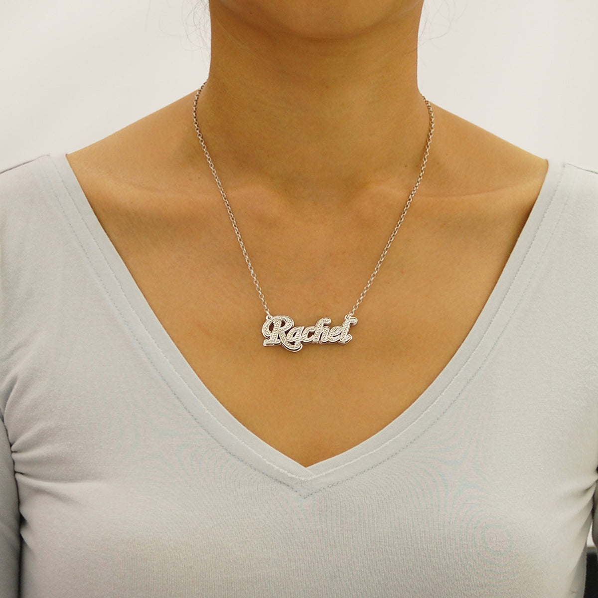 Model wearing a personalized sterling silver 3D double-plate nameplate necklace with diamond accents.