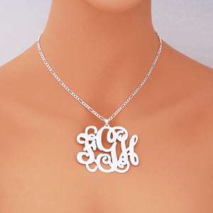 Model wearing a custom 2.5-inch 925 sterling silver monogram pendant necklace against a light orange background.