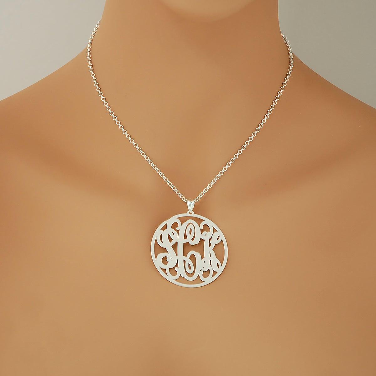 Woman wearing a personalized 1.75-inch sterling silver circle monogram necklace.