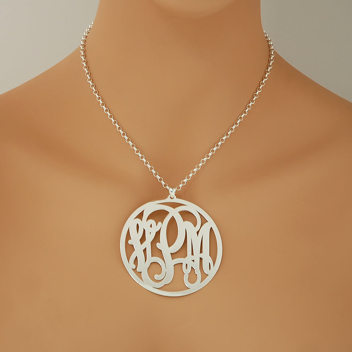 Woman wearing a personalized 2.5-inch sterling silver circle monogram pendant necklace.