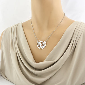 Woman wearing a personalized sterling silver heart monogram necklace with a 3-initial custom pendant.