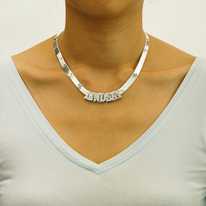 Model wearing the personalized 3D sterling silver name pendant paired with an 8mm herringbone chain around the neck.