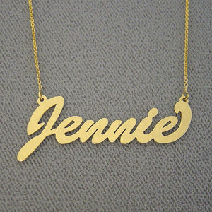 Close-up of a custom brushed gold cursive script nameplate pendant showing hand-finished texture.