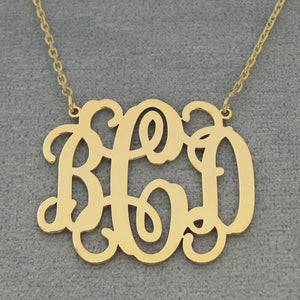 Custom solid gold 3 initial monogram necklace on a dark background