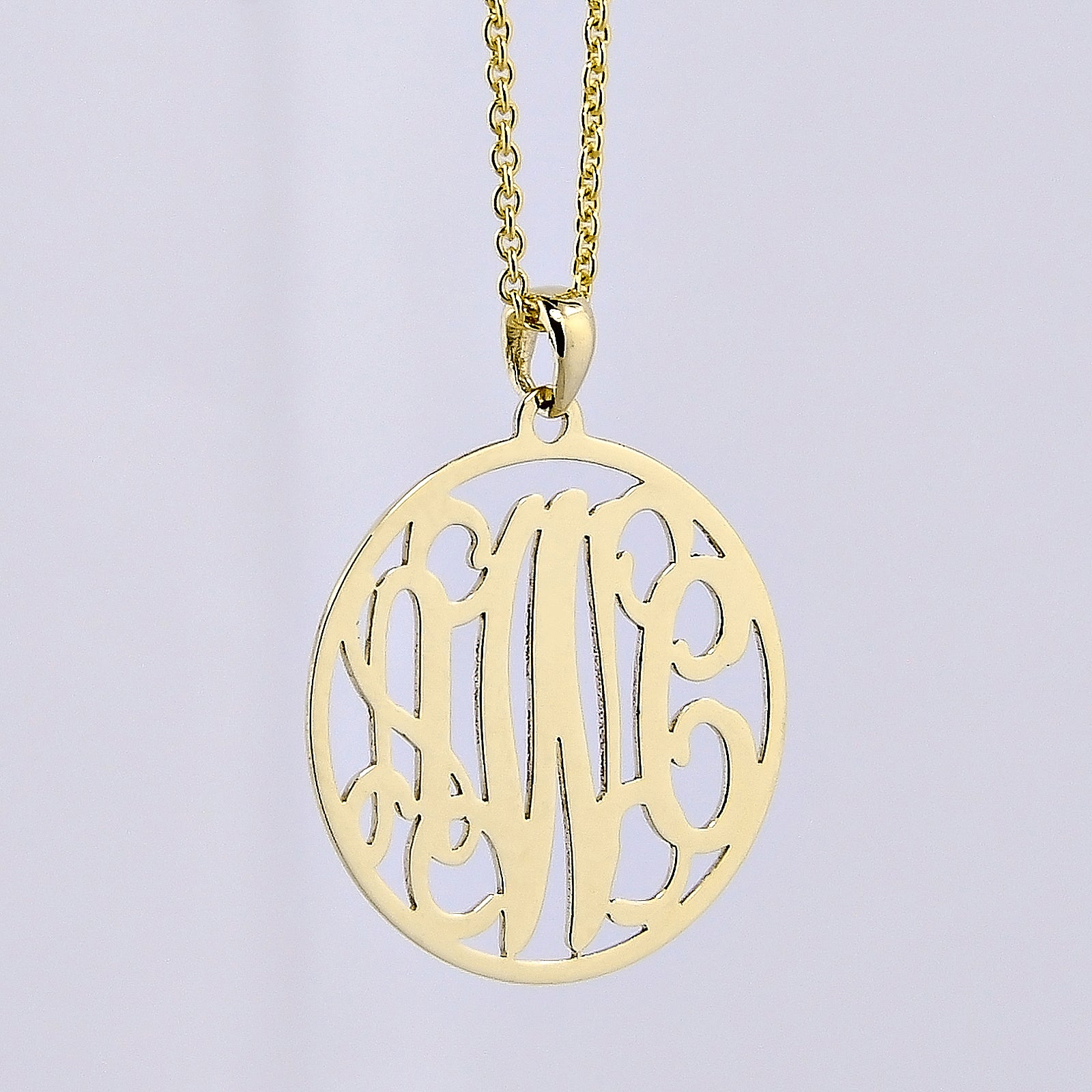 Custom solid gold 3-initial monogram pendant necklace on a delicate gold chain against a light gray background.
