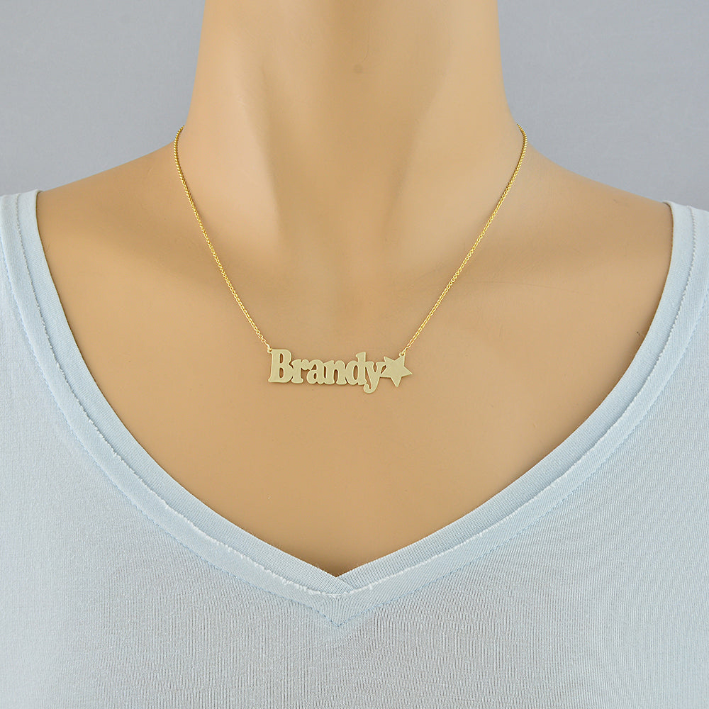 Custom solid gold star nameplate pendant necklace shown on a display mannequin.