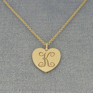 Custom laser engraved cursive letter K monogram on a solid gold heart disc pendant