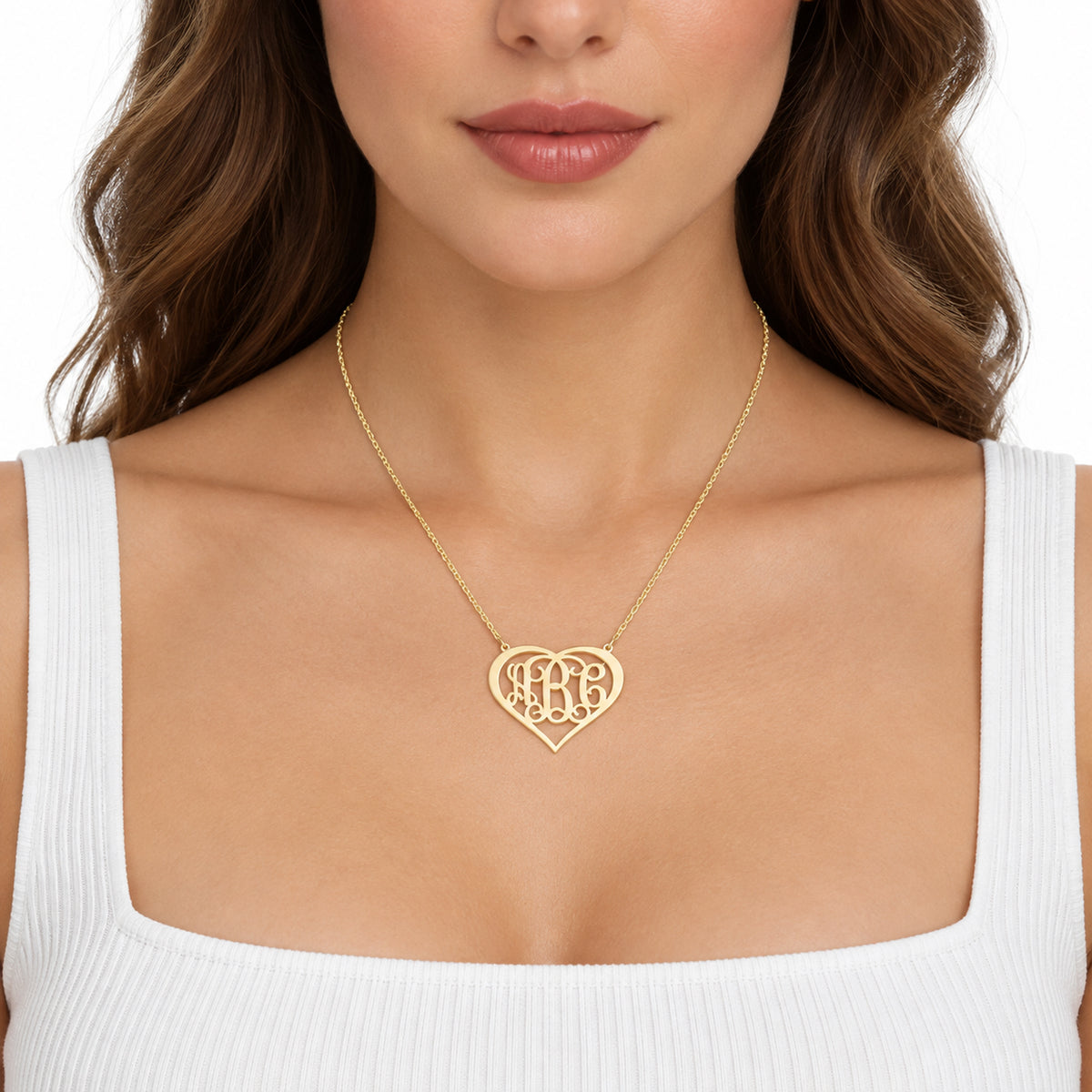Woman wearing a custom yellow solid gold three-initial heart monogram necklace