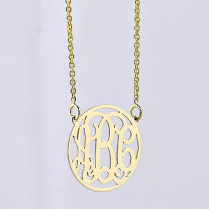 Close-up of an extra small 1/2-inch solid gold circle monogram necklace with a three-initial pendant.