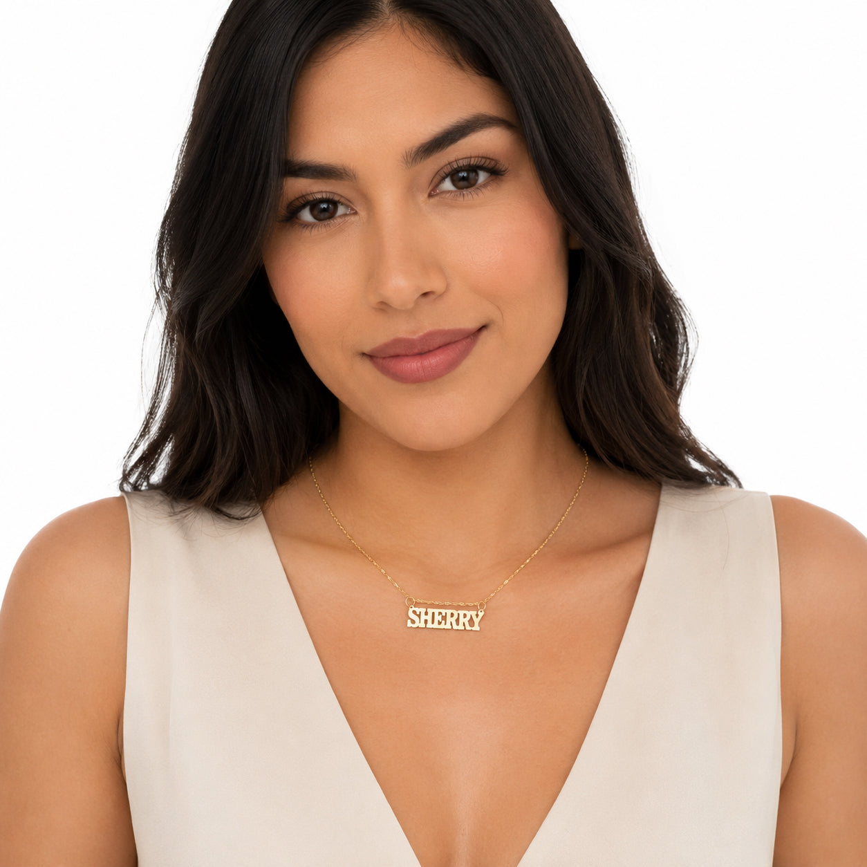 Model wearing a small solid gold block font personalized nameplate pendant necklace.