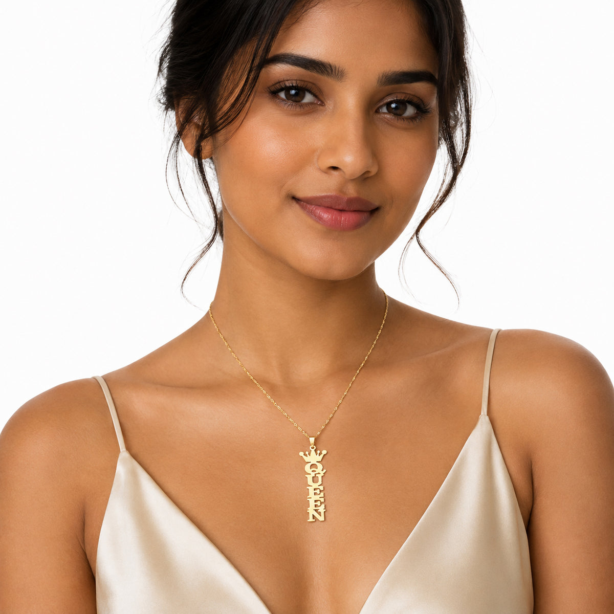 Woman wearing a yellow gold vertical QUEEN crown name pendant on a delicate chain.