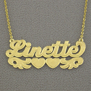 Close-up shot showing hand-engraved check-pattern lettering detail on 10k and 14k gold nameplates side-by-side.