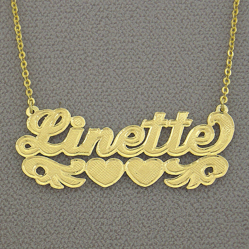 Close-up shot showing hand-engraved check-pattern lettering detail on 10k and 14k gold nameplates side-by-side.