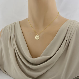 Mannequin wearing a 16 inches gold necklace featuring a round monogrammed disc.