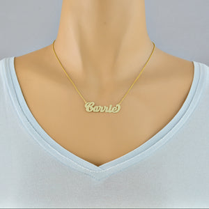 Model wearing a small personalized solid gold script nameplate necklace.