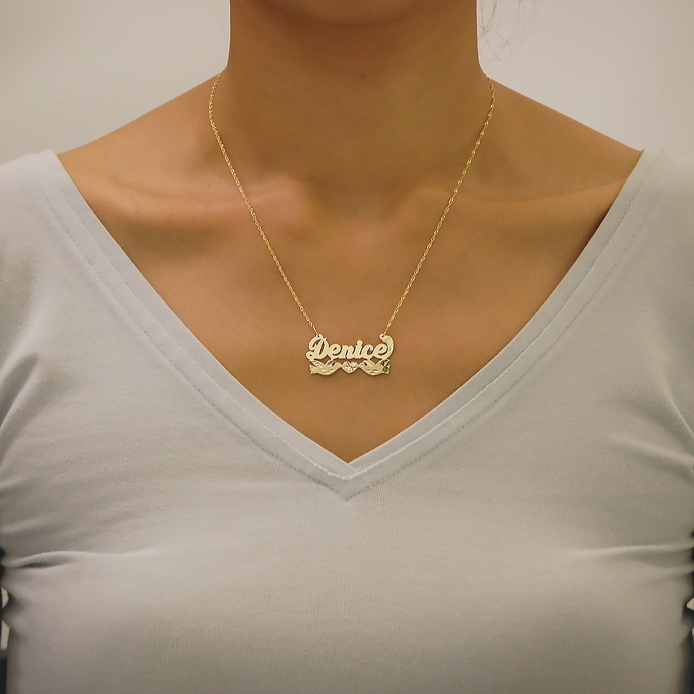 Model wearing personalized solid gold kissing birds nameplate pendant necklace on 15 inch rolo chain.