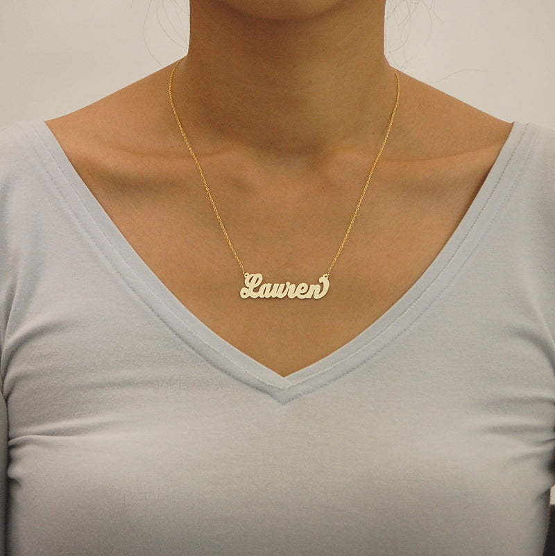 Model wearing a personalized 14k gold script name necklace displaying fine craftsmanship and fit.