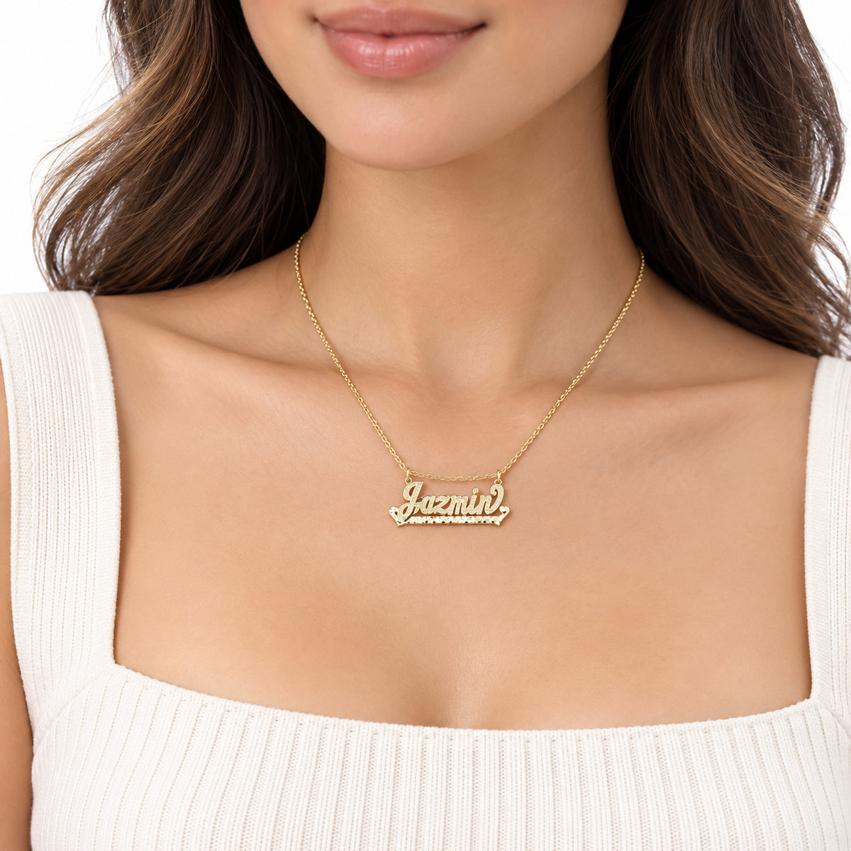 Woman wearing a personalized solid gold cursive nameplate necklace.