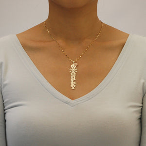 Model wearing a custom gold vertical nameplate necklace attached to an 18-inch gold chain.