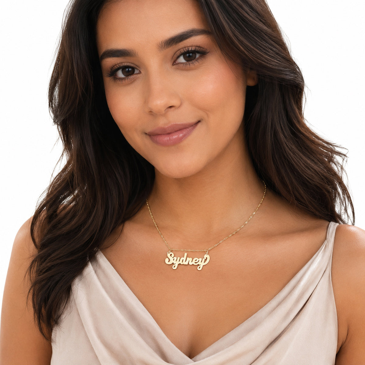 Model wearing a small handcrafted solid gold custom script Sydney nameplate necklace paired with a beige top.