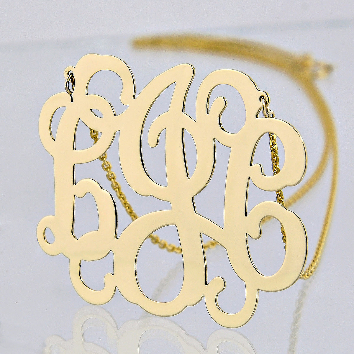 Detailed view of personalized solid gold monogram pendant