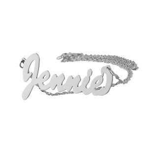 Close-up detail of the small personalized white gold cursive script nameplate showing custom-brushed lettering.