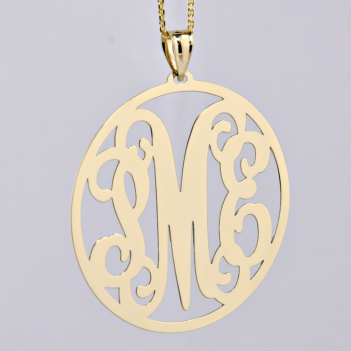 Close-up of 1.5-inch solid gold monogram necklace with elegant engraved initials