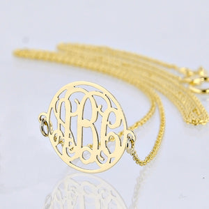 Detailed view of a solid gold three-initial circle monogram necklace pendant and chain