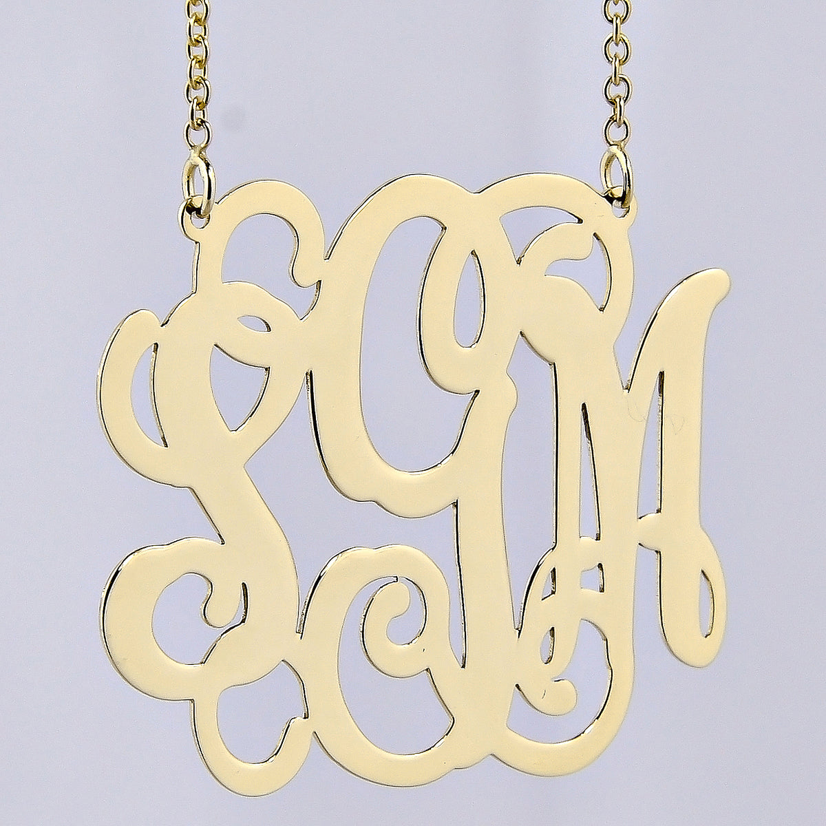 Detailed view of a custom 10k or 14k solid gold 3 initial monogram pendant