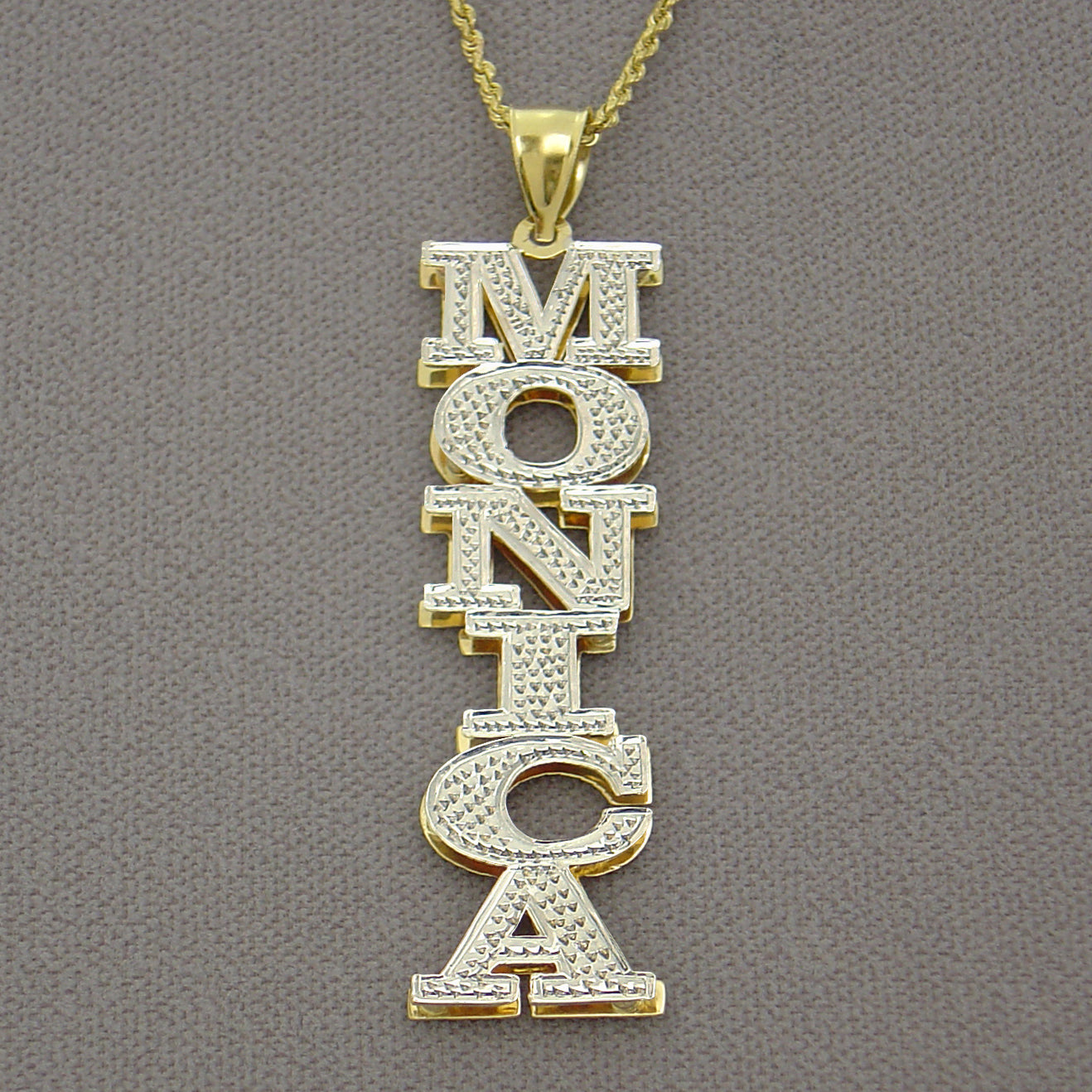 Close-up of two-tone 14K gold 3D double plate personalized name pendant