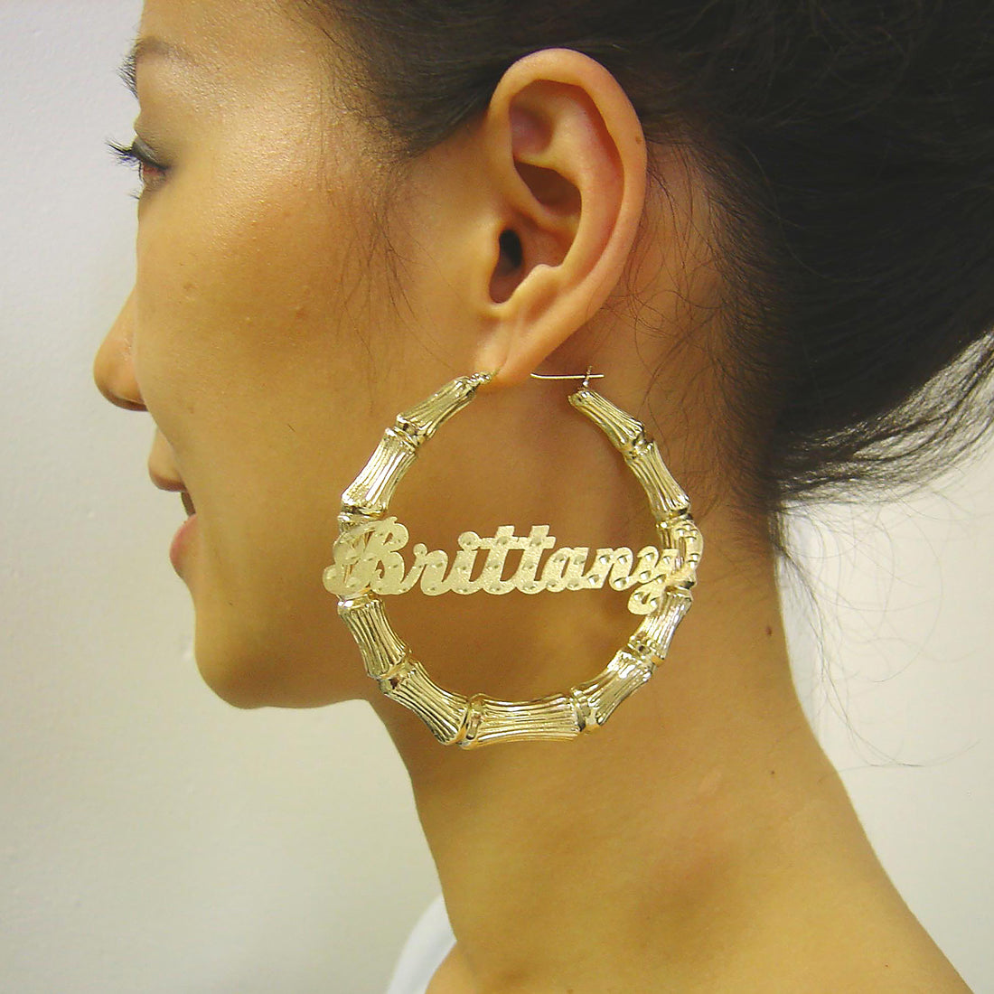 Detailed close up of 10K real gold personalized name plate on bamboo hoop earrings