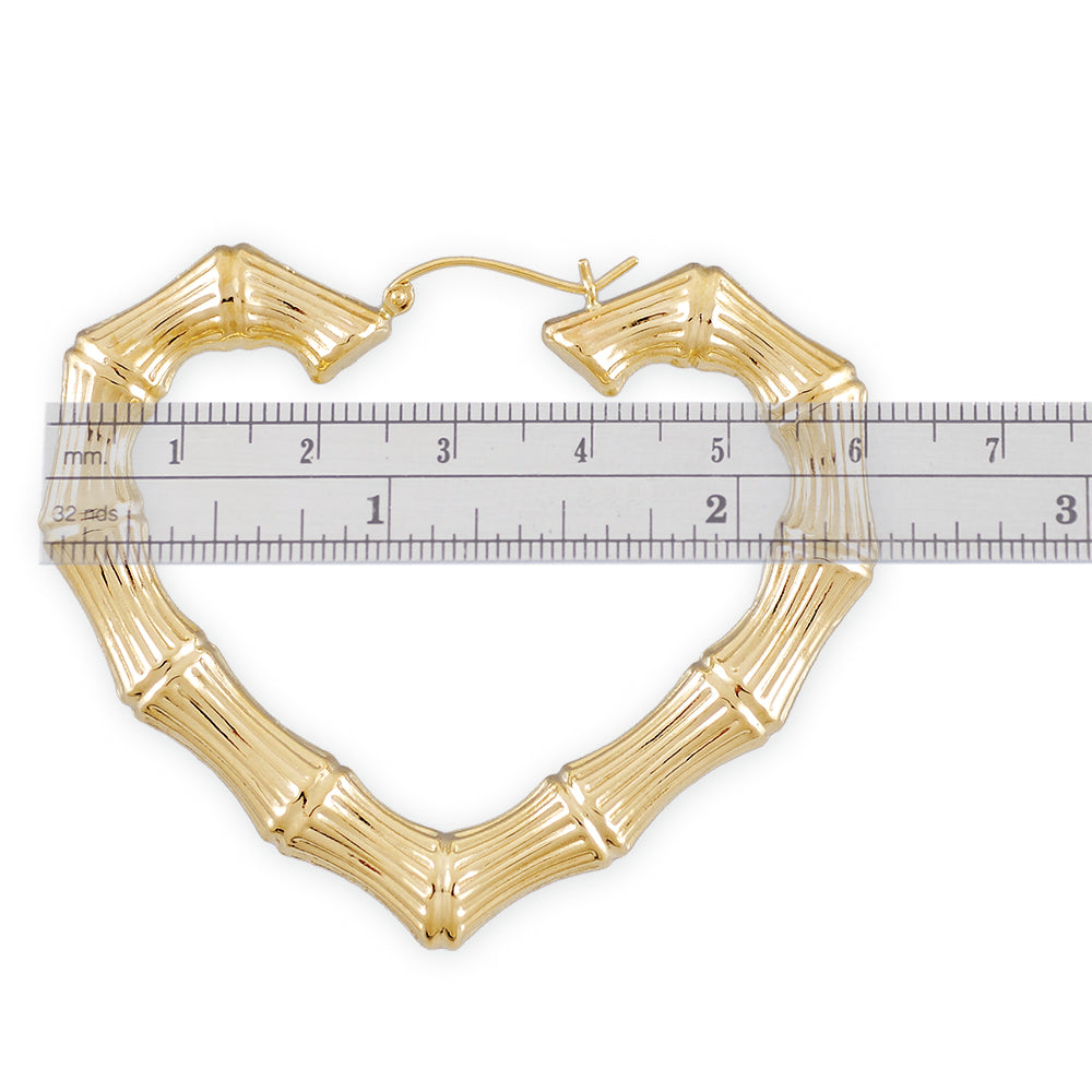 Close-up of hollow 10K yellow gold heart-shaped bamboo hoop earring