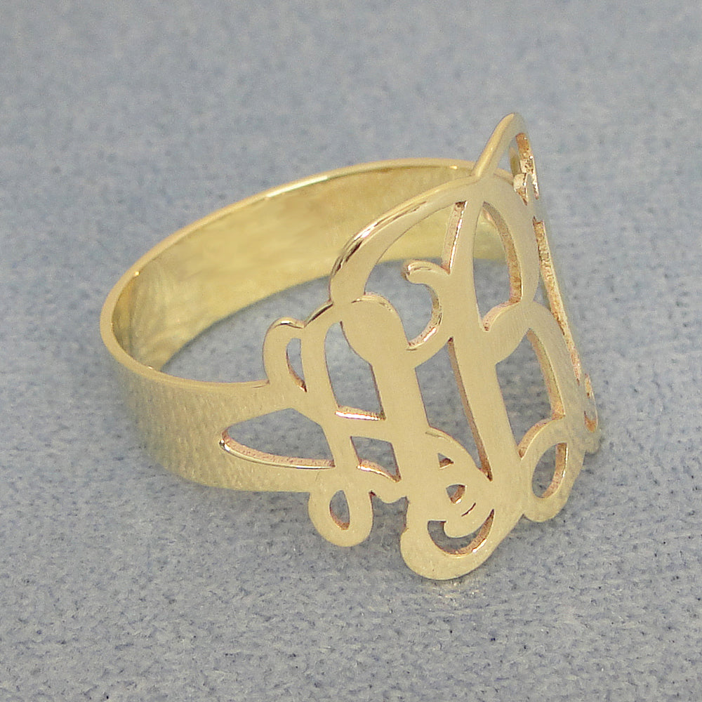 Front angle view of handcrafted 3-initial monogram gold ring showing letter engraving detail