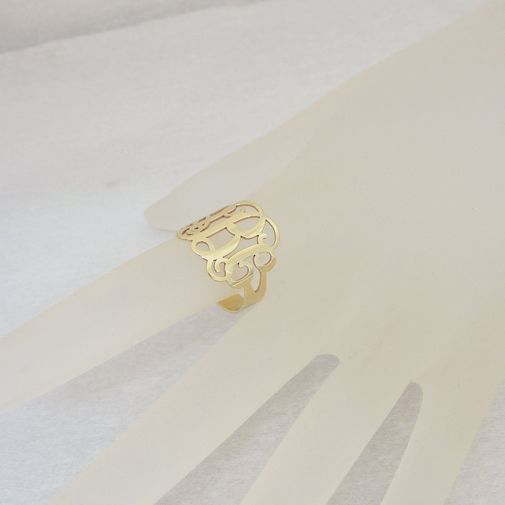 wearing personalized solid gold 3-initial monogram ring on finger