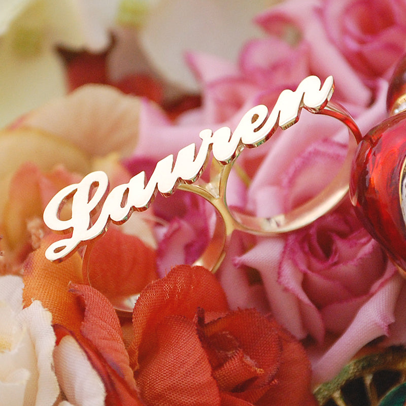 Close-up of handcrafted script cursive lettering on custom solid gold two-finger ring