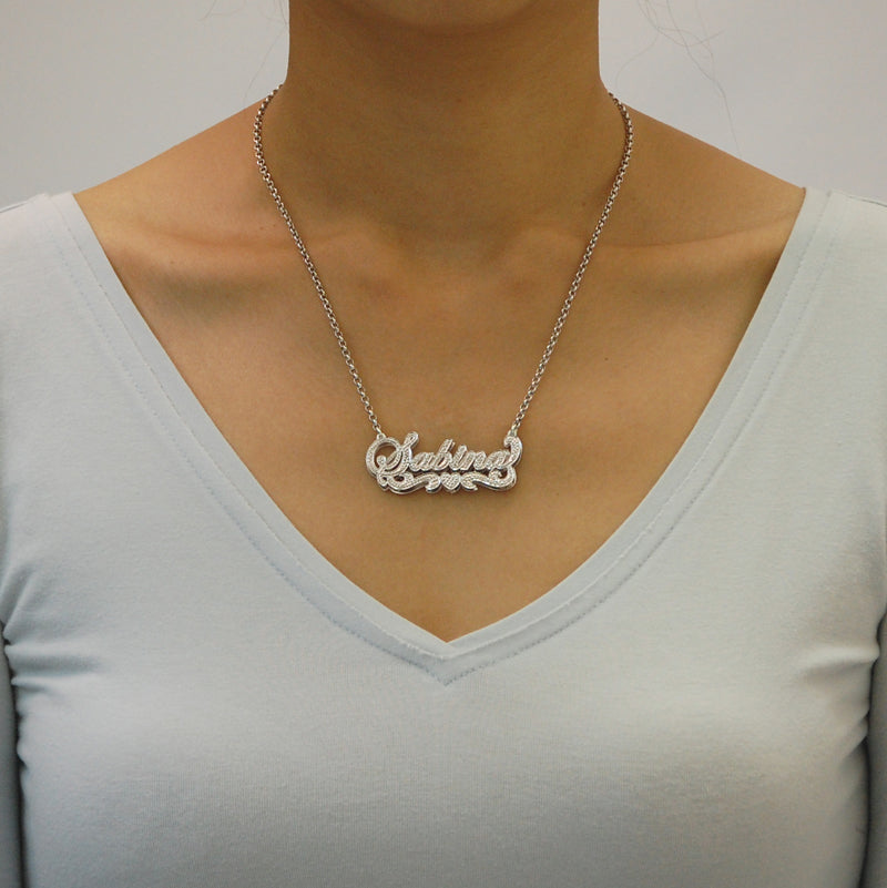 Model wearing personalized sterling silver Sabina nameplate necklace with 18-inch rolo chain