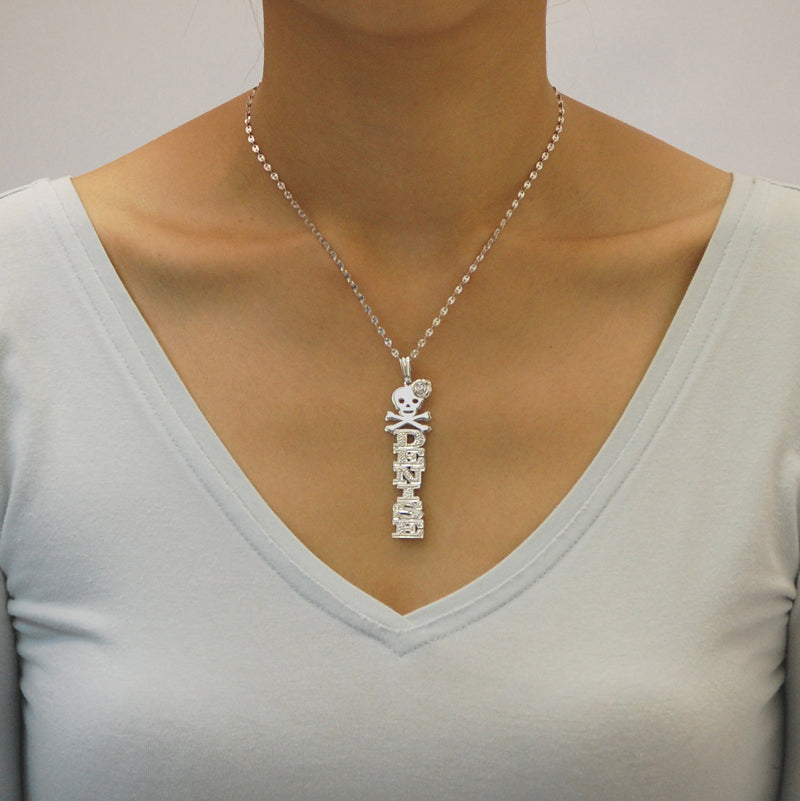 Woman wearing a personalized sterling silver 3D vertical name pendant necklace with skull and rose detailing.