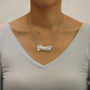 Model wearing a custom personalized sterling silver 3D nameplate necklace with star charms.