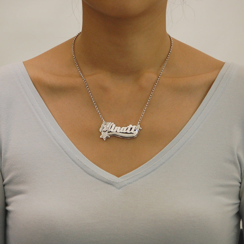 Model wearing a custom personalized sterling silver 3D nameplate necklace with star charms.