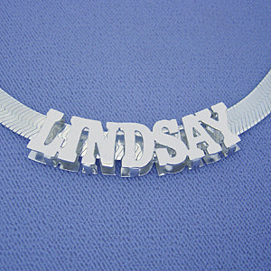 Sterling silver custom 3D block nameplate necklace spelling "LINDSAY" on a blue background.