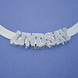 Close-up view of the 8mm sterling silver herringbone chain showcasing the smooth lay and lobster clasp enclosure.